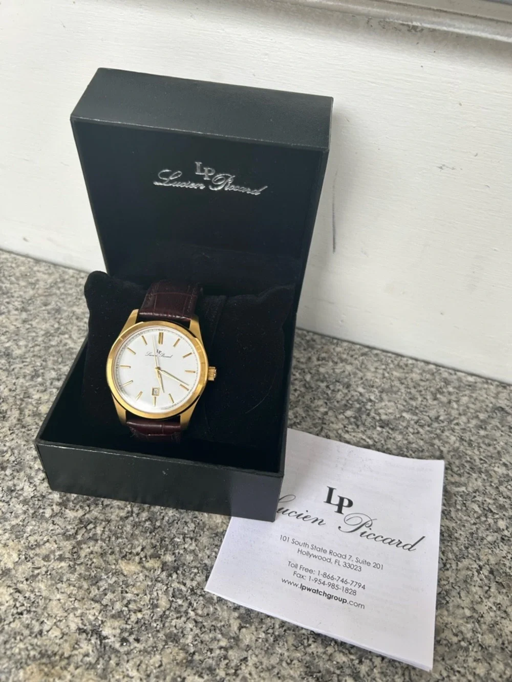 Lucien Piccard Gold Tone Case with Brown Strap and White Dial Accents